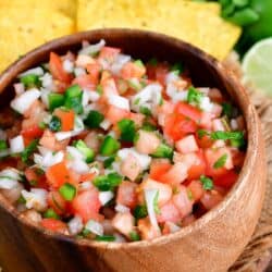Pico de Gallo in a wood bowl on a burlap placemat.