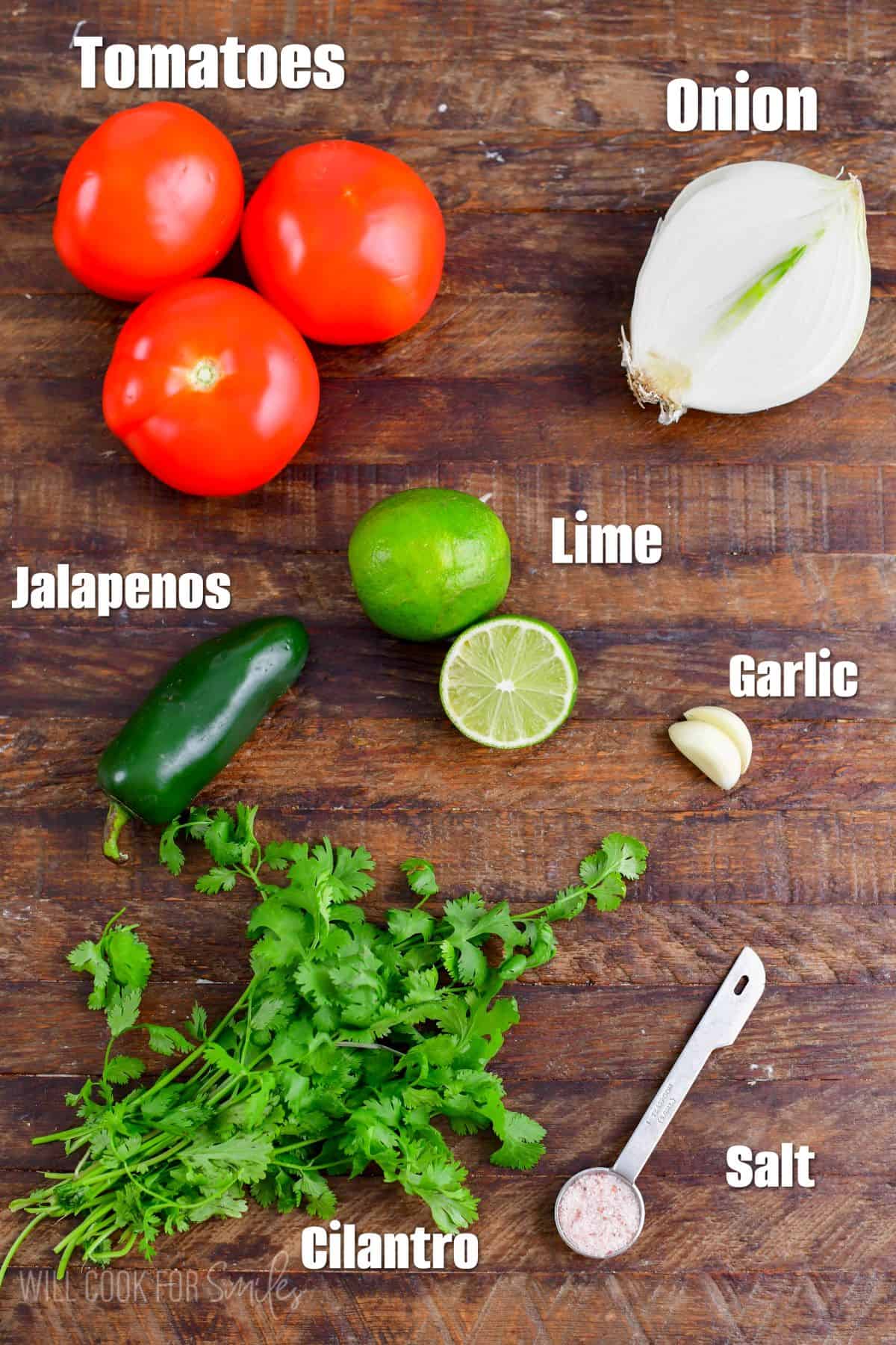 Labeled ingredients for Pico de Gallo on a wood surface.