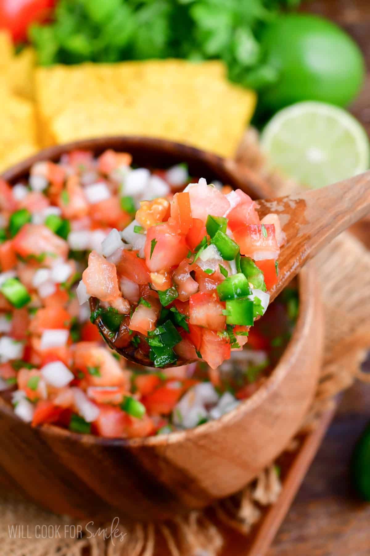 scooping up Pico de Gallo up with a wooden spoon.