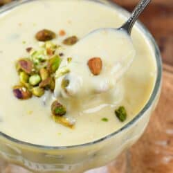 pistachio pudding in a bowl and a spoon scooping some out.