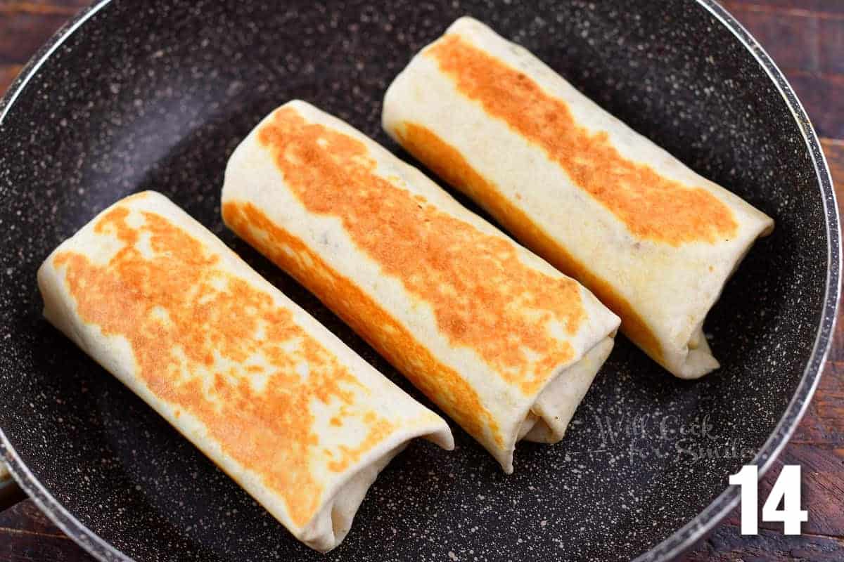 searing three breakfast burritos in a cooking pan.