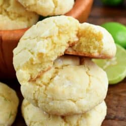 A stack of coconut cream cheese cookies with the top cookie cut in half.