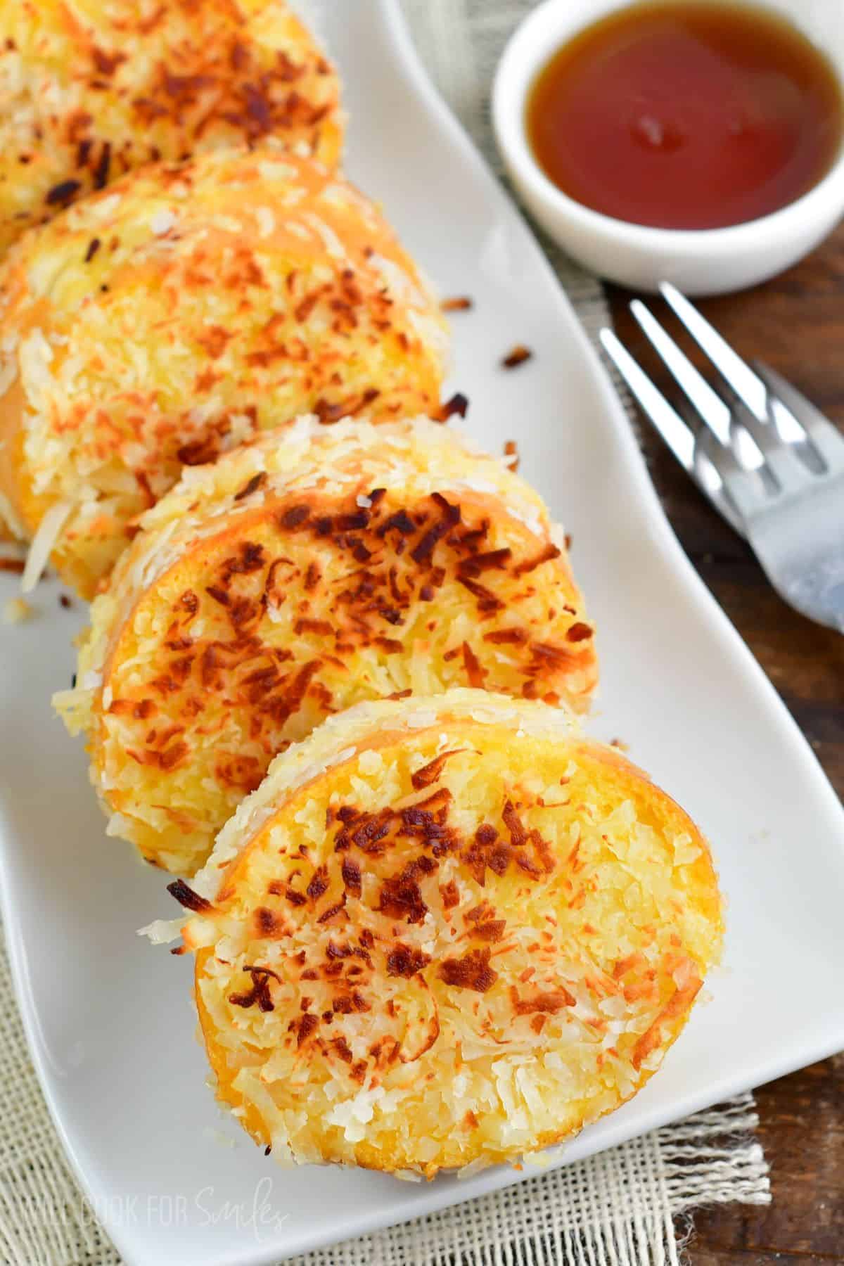 several slices of coconut crusted and stuffed French toast stacked side by side.