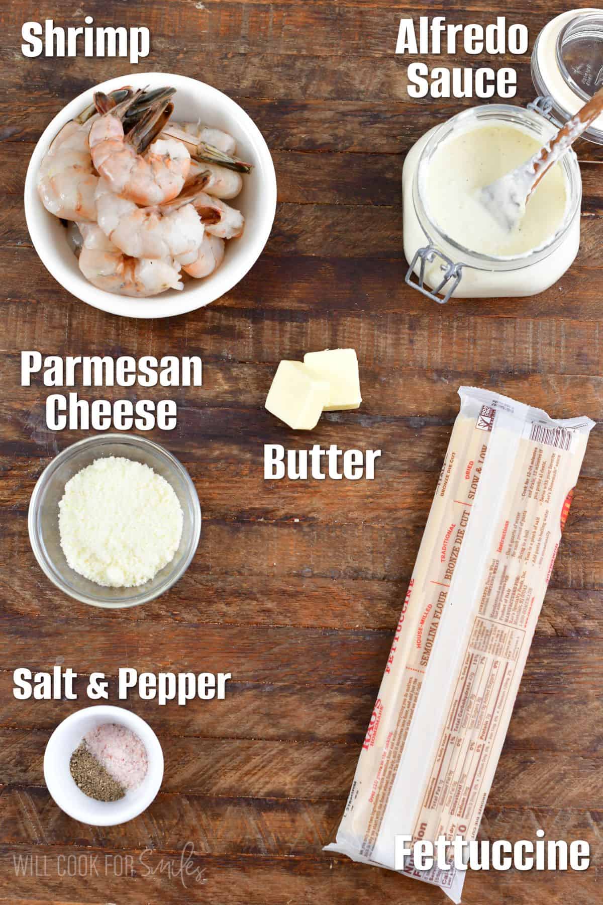 Labeled ingredients for shrimp alfredo on a wood surface.