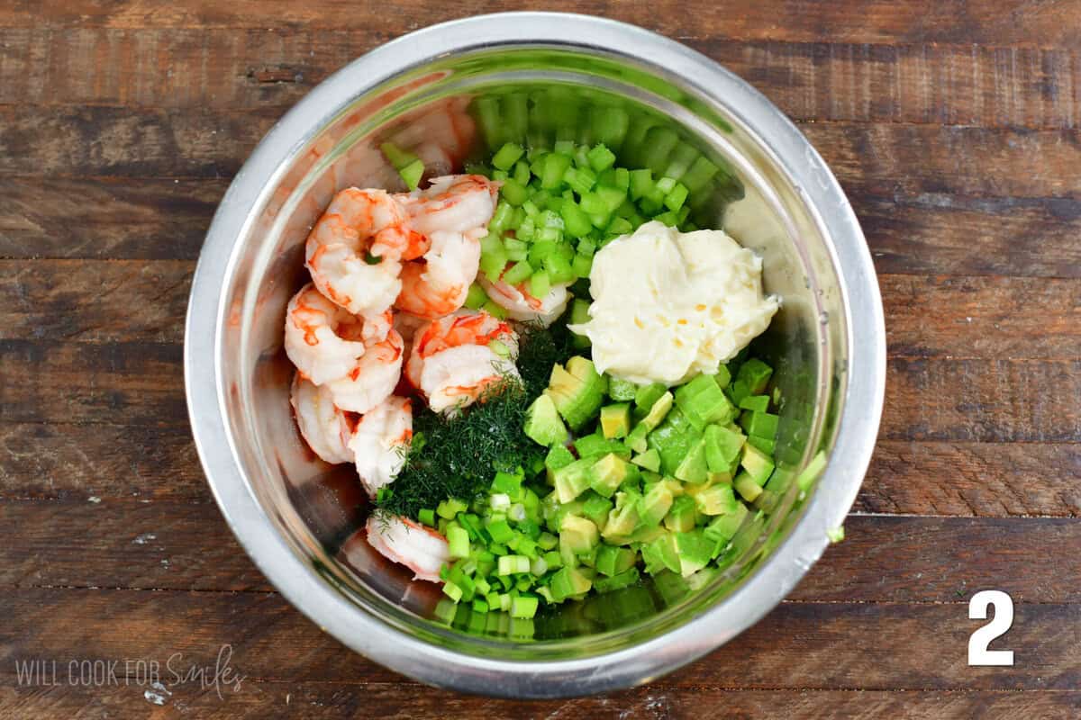 Shrimp , diced avocado, celery, Green onion and mayo in a bowl for minced fresh dill weed.