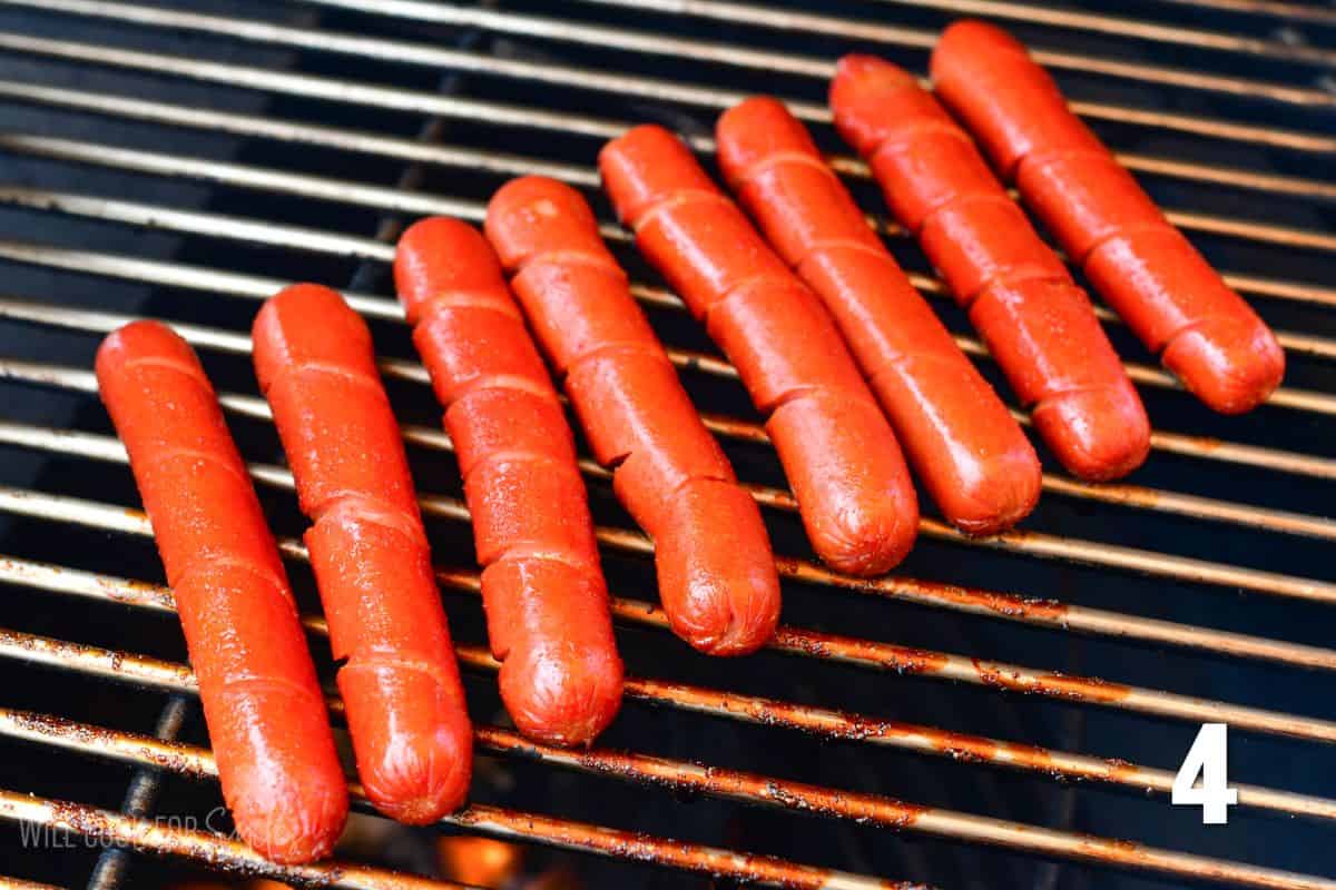 spiral cut hotdogs cooking on a grill.