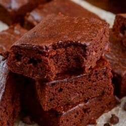 Pumpkin brownies stacked up with the a bite out of the top brownie.