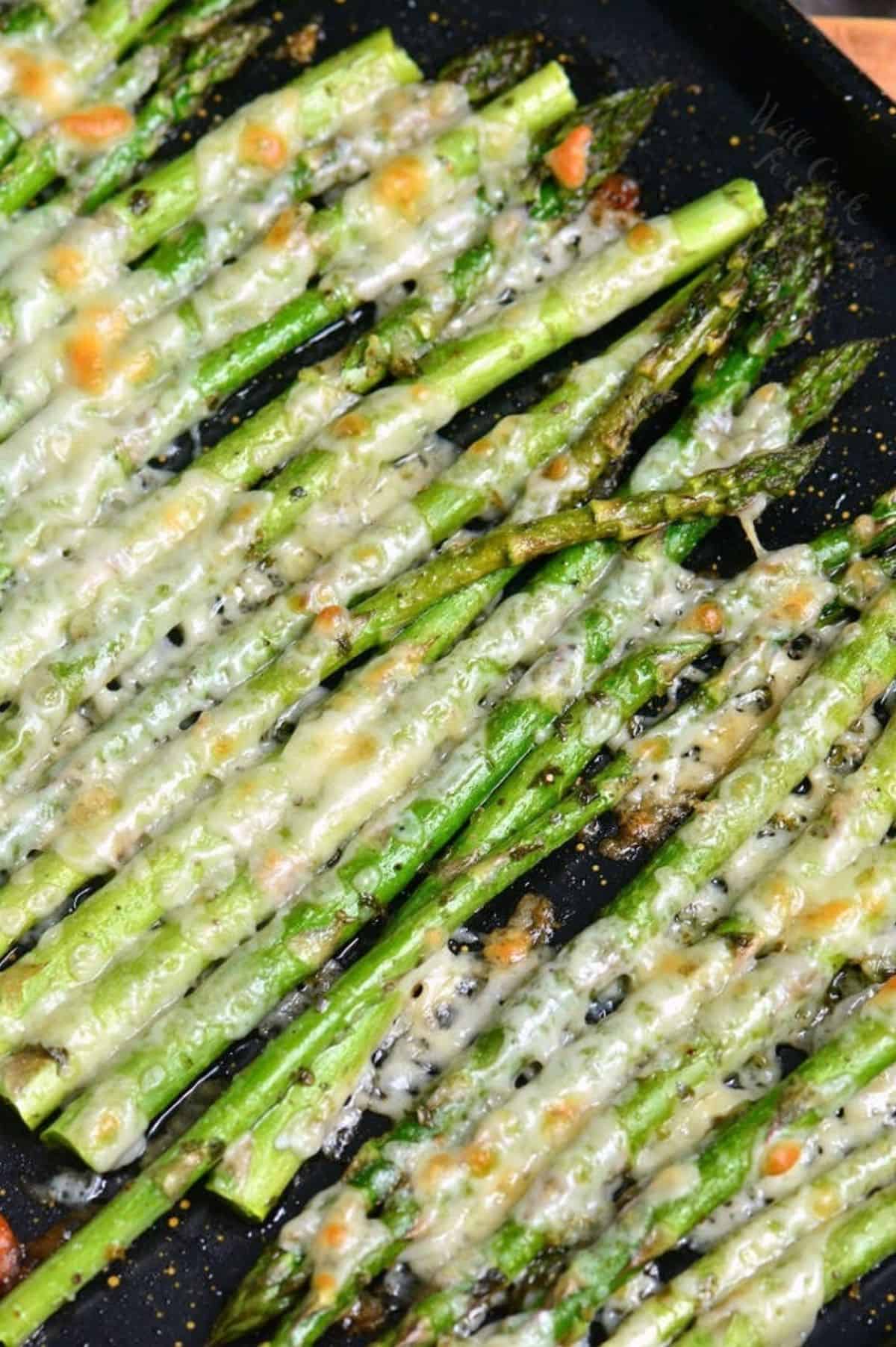 oven roasted asparagus with Italian seasoning and parmesan cheese on a baking sheet.