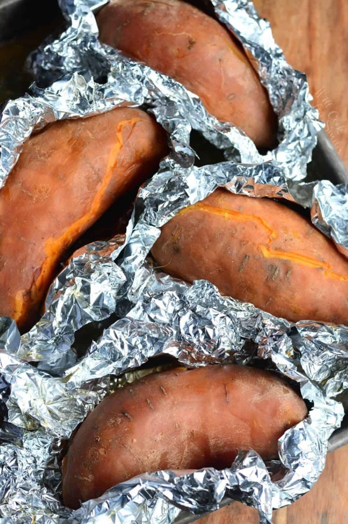 baked sweet potatoes individually wrapped in foil, after baking.