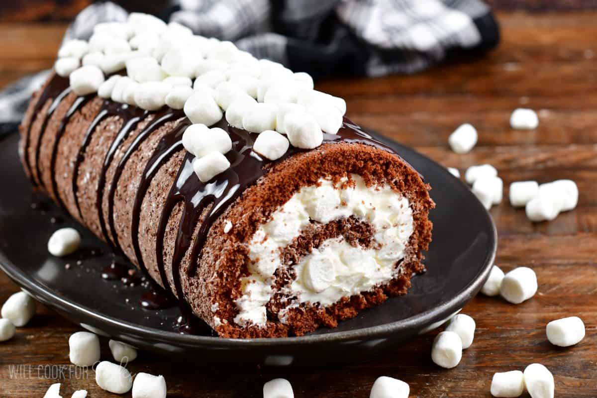 finished hot chocolate care roll topped with marshmallows on the black serving dish. 