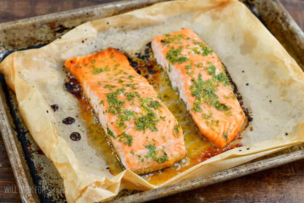 juicy baked cilantro honey lime salmon filets on a baking sheet.