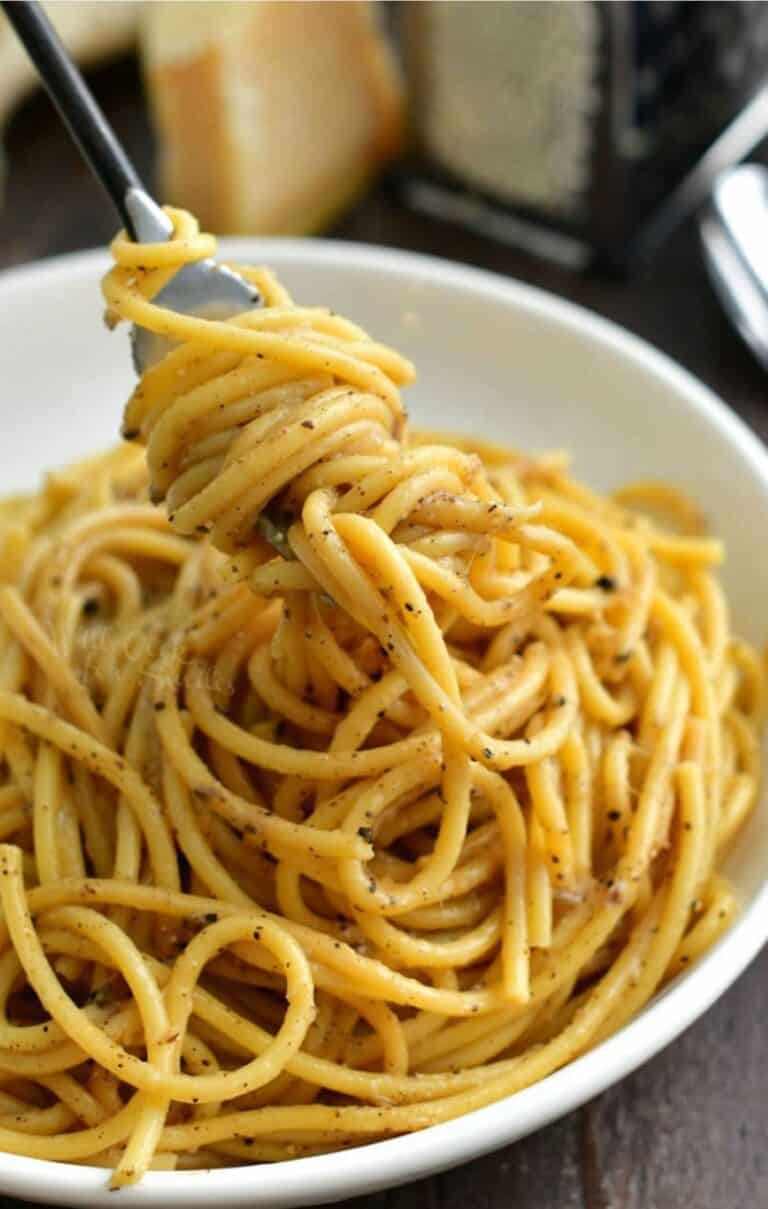 swirling some cheesy cacio e pepe pasta onto the fork from the bowl.