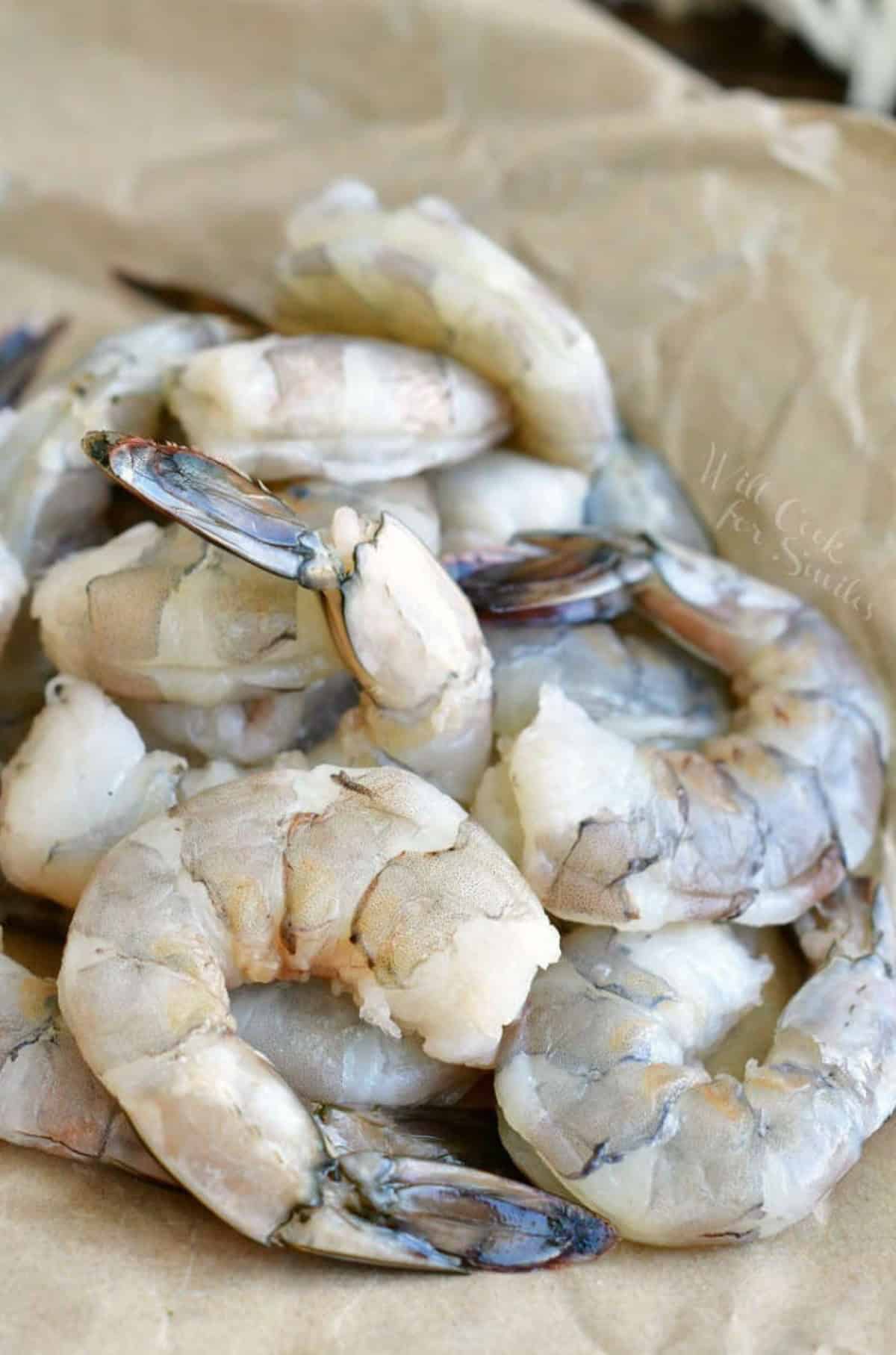 peeled and devievned shrimp laying on parchement paper.