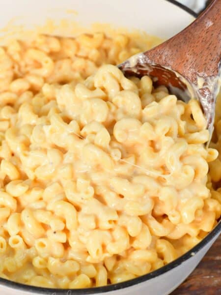 scooping a big ladle full of gooey, creamy, and cheesy mac and cheese.