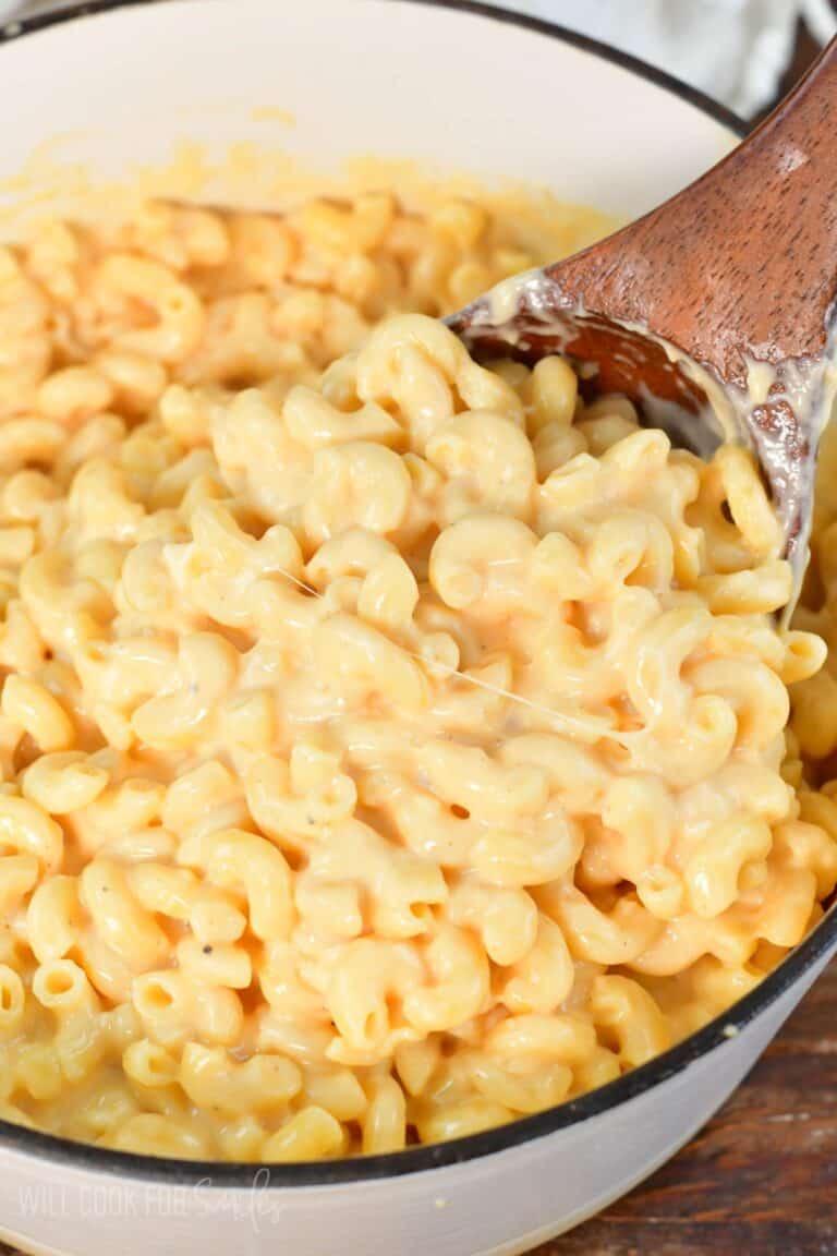 scooping a big ladle full of gooey, creamy, and cheesy mac and cheese.