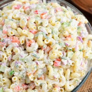 Macaroni salad in a big serving bowl on a wood surface.