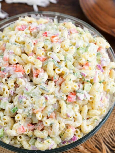 Macaroni salad in a big serving bowl on a wood surface.