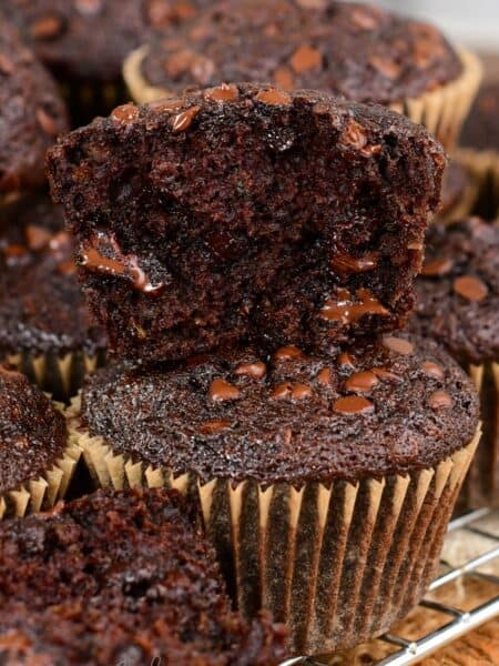 Chocolate zucchini muffins one cut in half on top of a whole muffin.