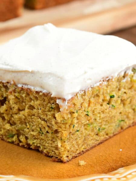 once slice of zucchini cake on a plate with cream cheese frosting.