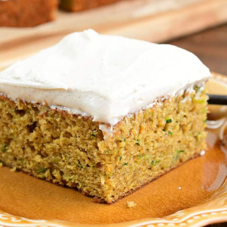 once slice of zucchini cake on a plate with cream cheese frosting.