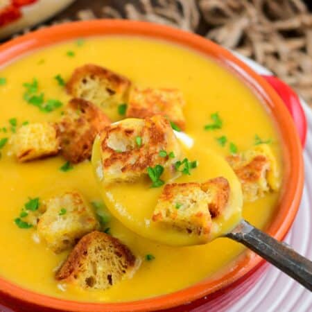 spooning out some Butternut squash potato soup with two croutons as well.