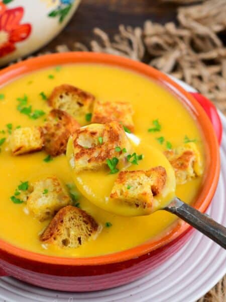 spooning out some Butternut squash potato soup with two croutons as well.