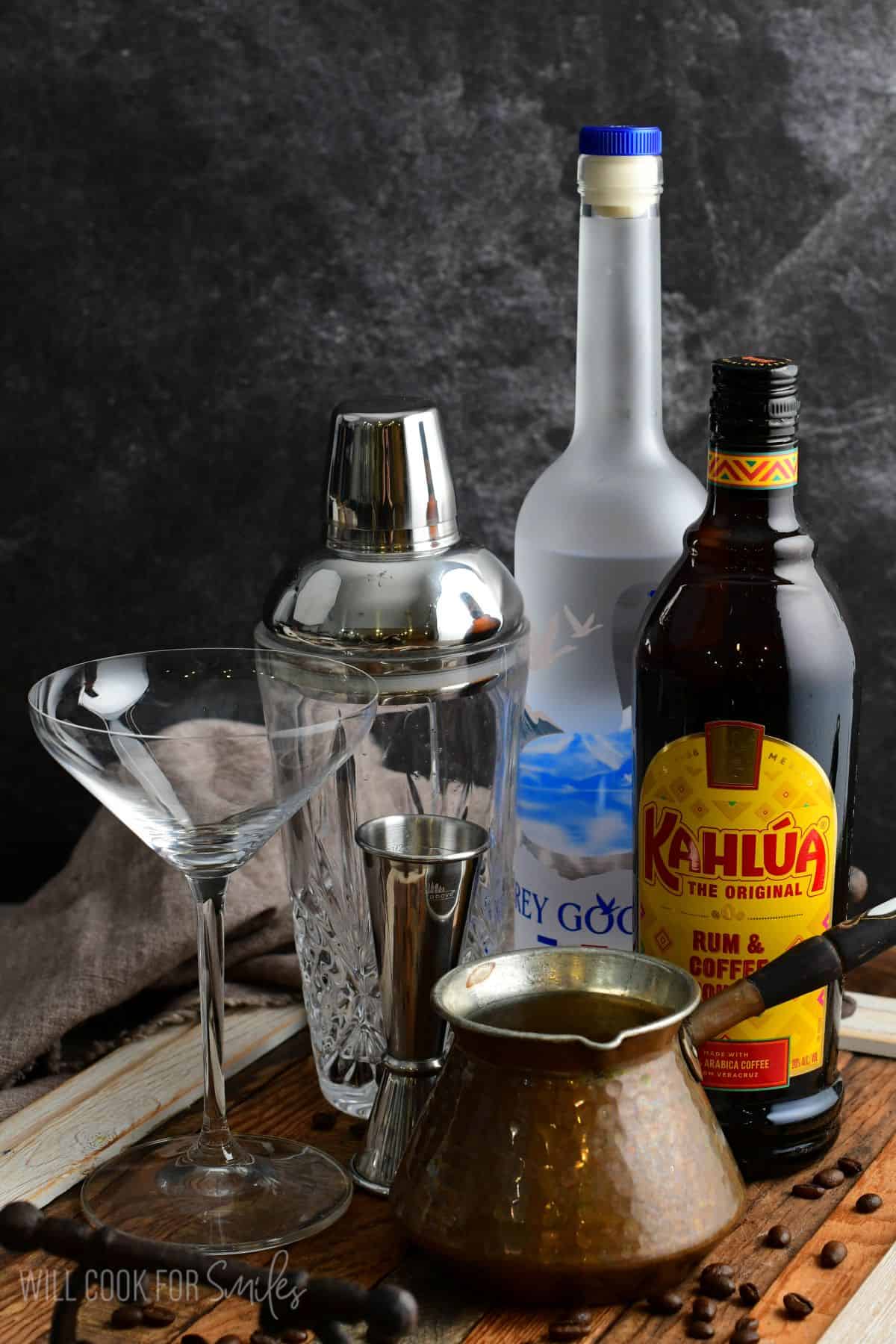 Ingredients for espresso martini on a wood surface.