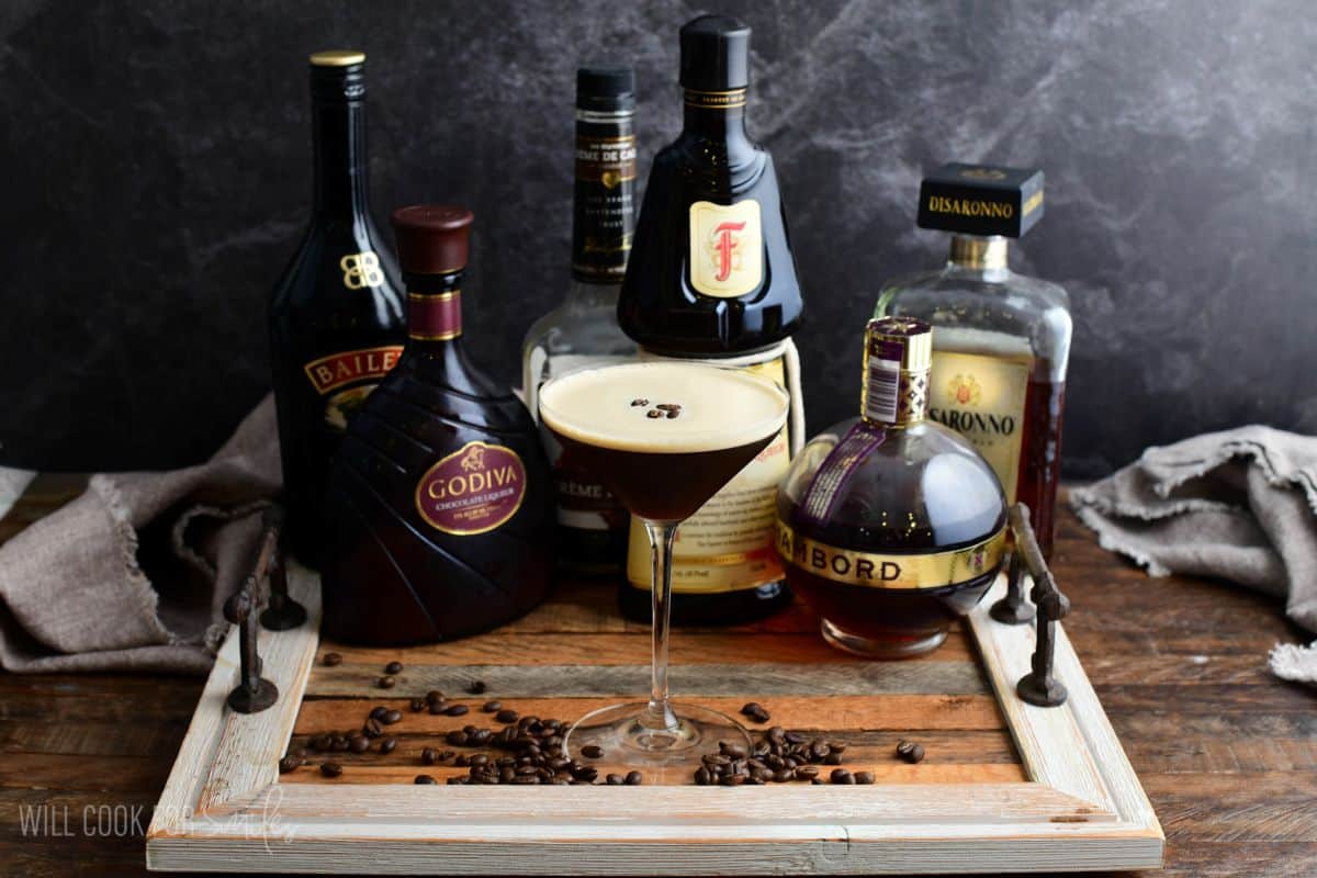 An espresso martini on a wood tray with all the optional flavors.
