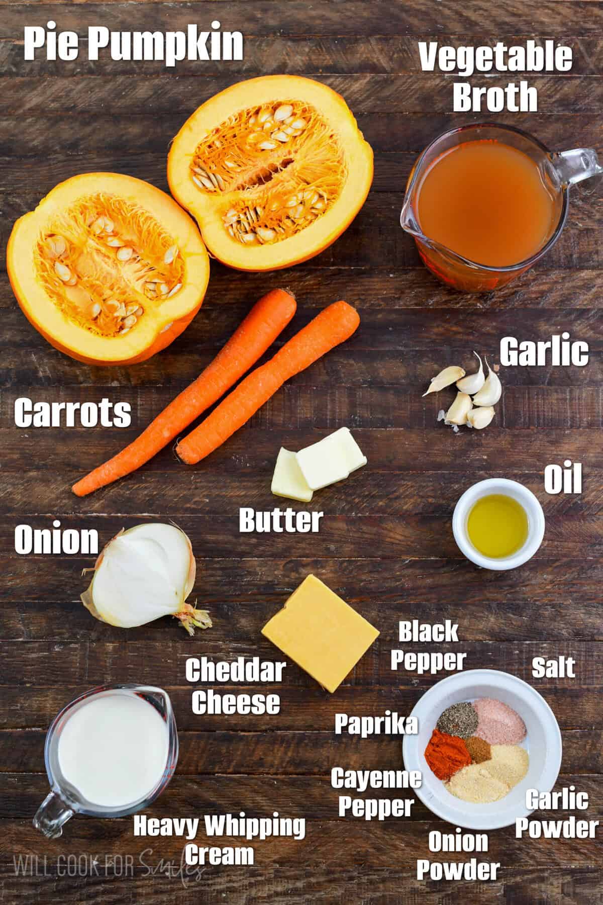 Labeled ingredients for pumpkin soup on a wood surface.