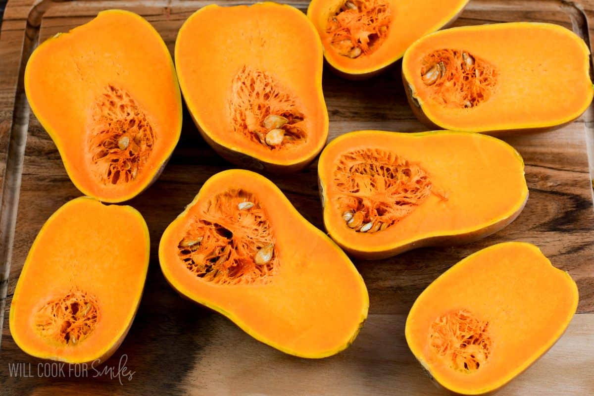 honeynut squash cut in half on a wood surface.