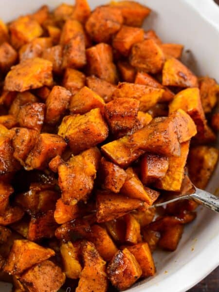 Spiced roasted honeynut sqaush in a bowl with a spoon scooping some out.