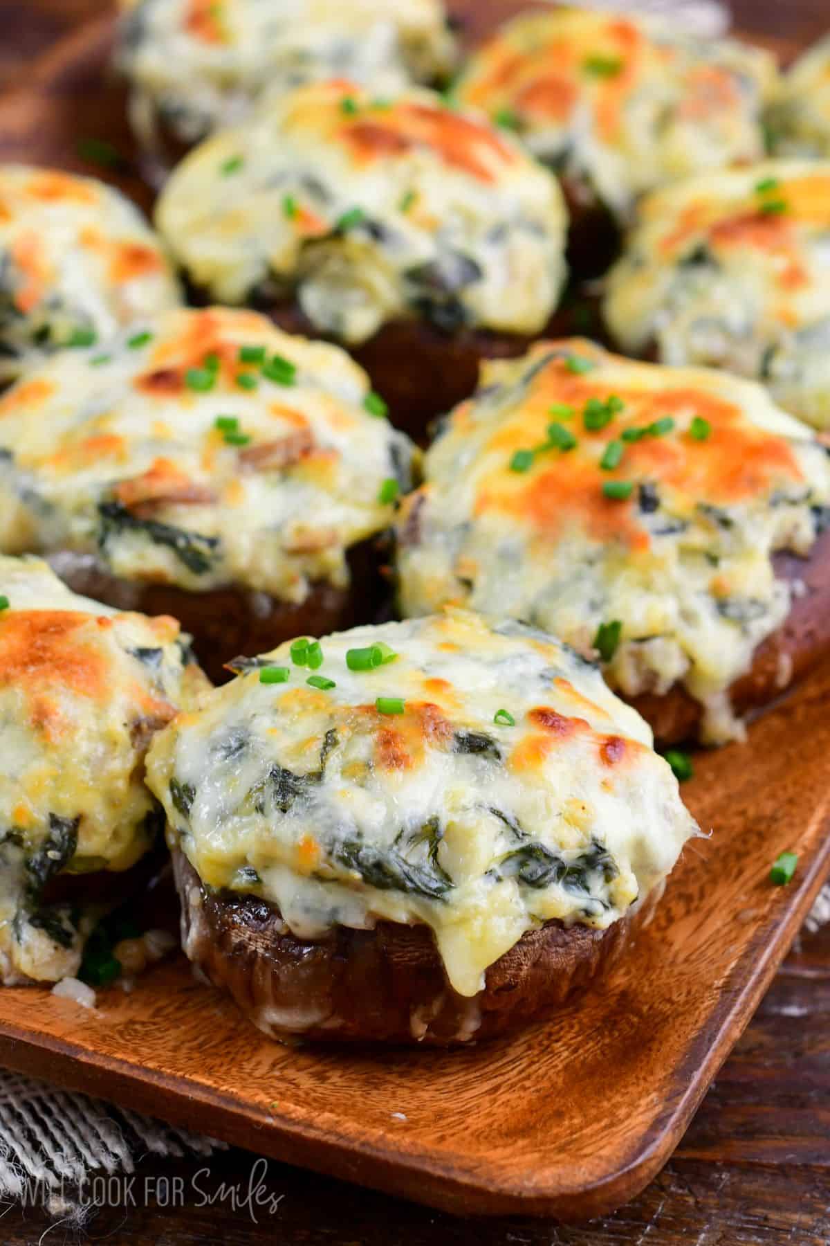 several spinach artichoke stuffed mushrooms with golden melted mozzarella cheese on top.