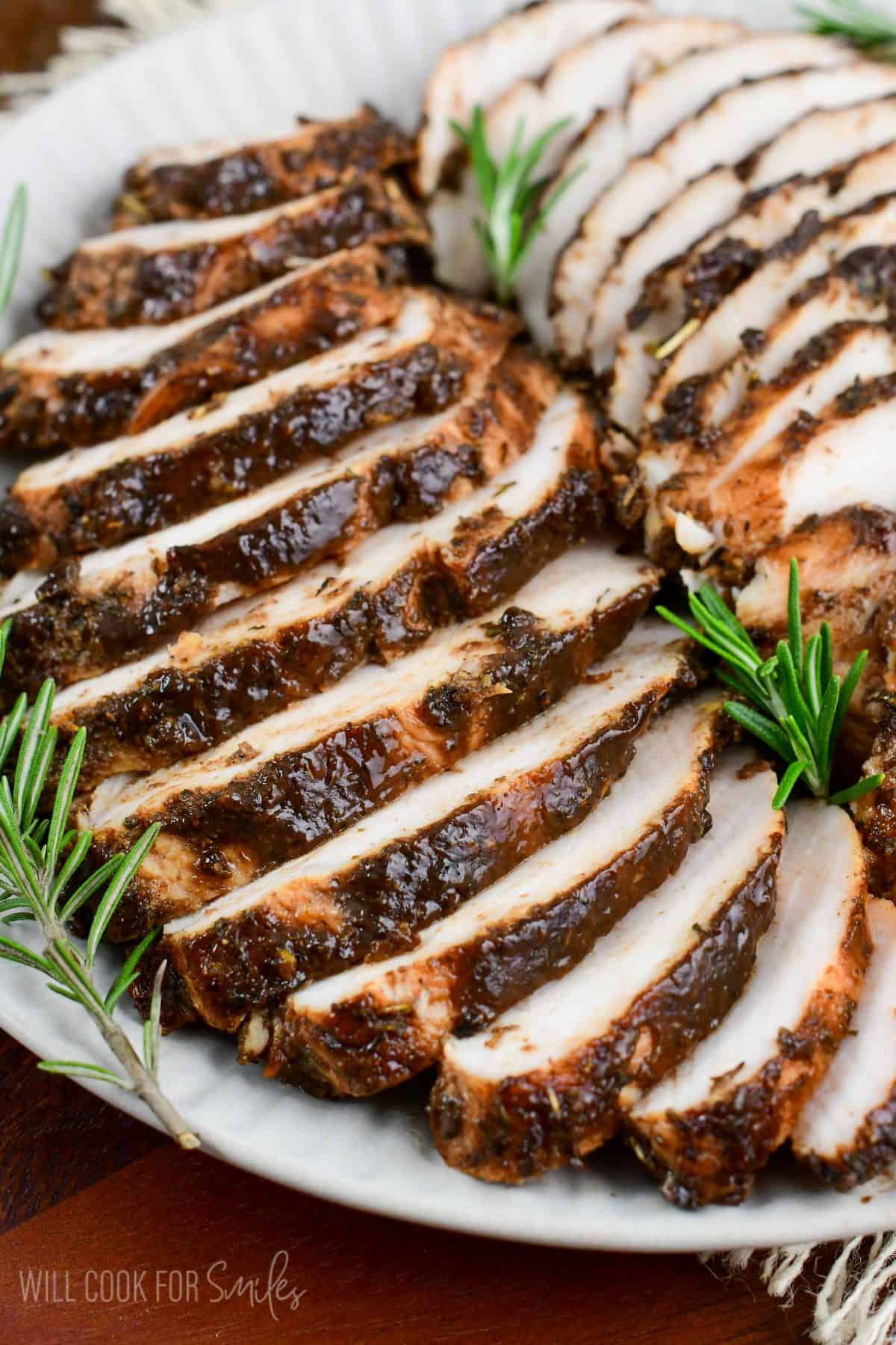 juicy and flavorful turkey tenderloin in a balsamic and Italian seasoning mixture sliced on a platter.