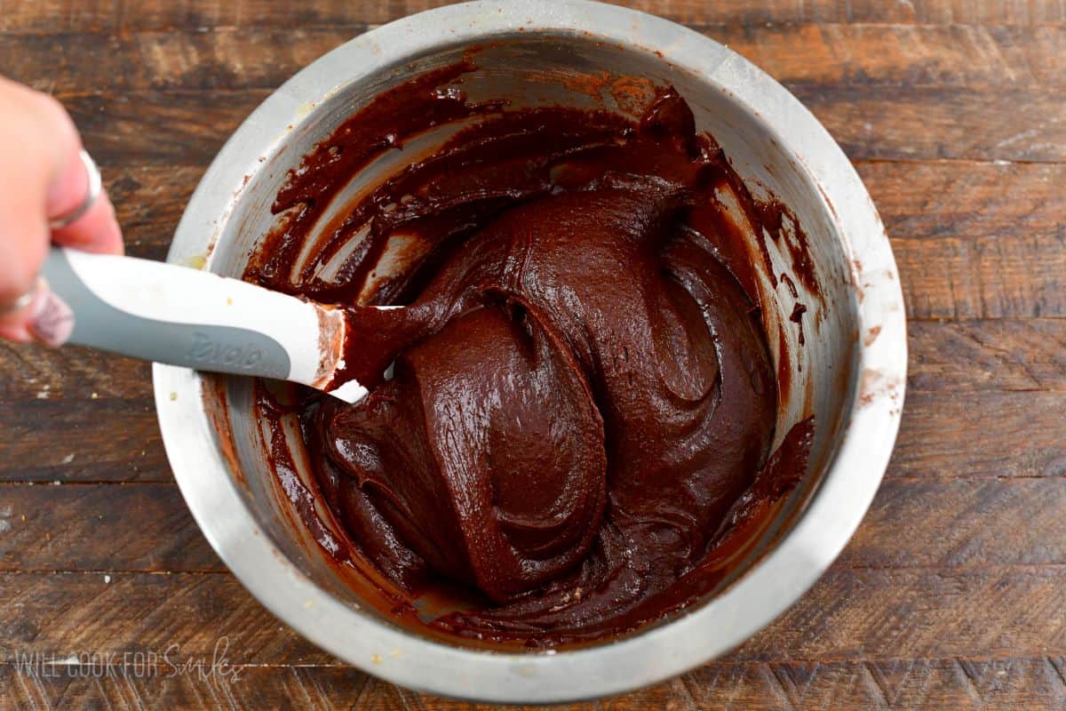 Stirring the chocolate cookie batter in a mixing bowl.