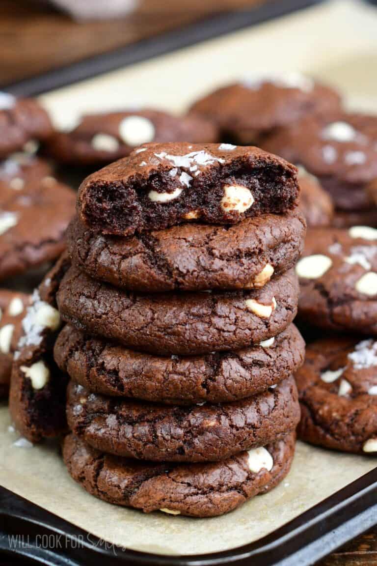 Chocolate brown butter cookies stacked up and the top cookie has been broken in half.