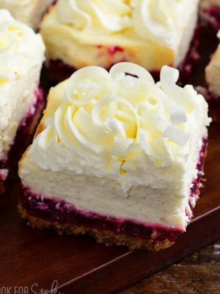 closeup on a square of Christmas cheesecake bar with white chocolate shavings on top.