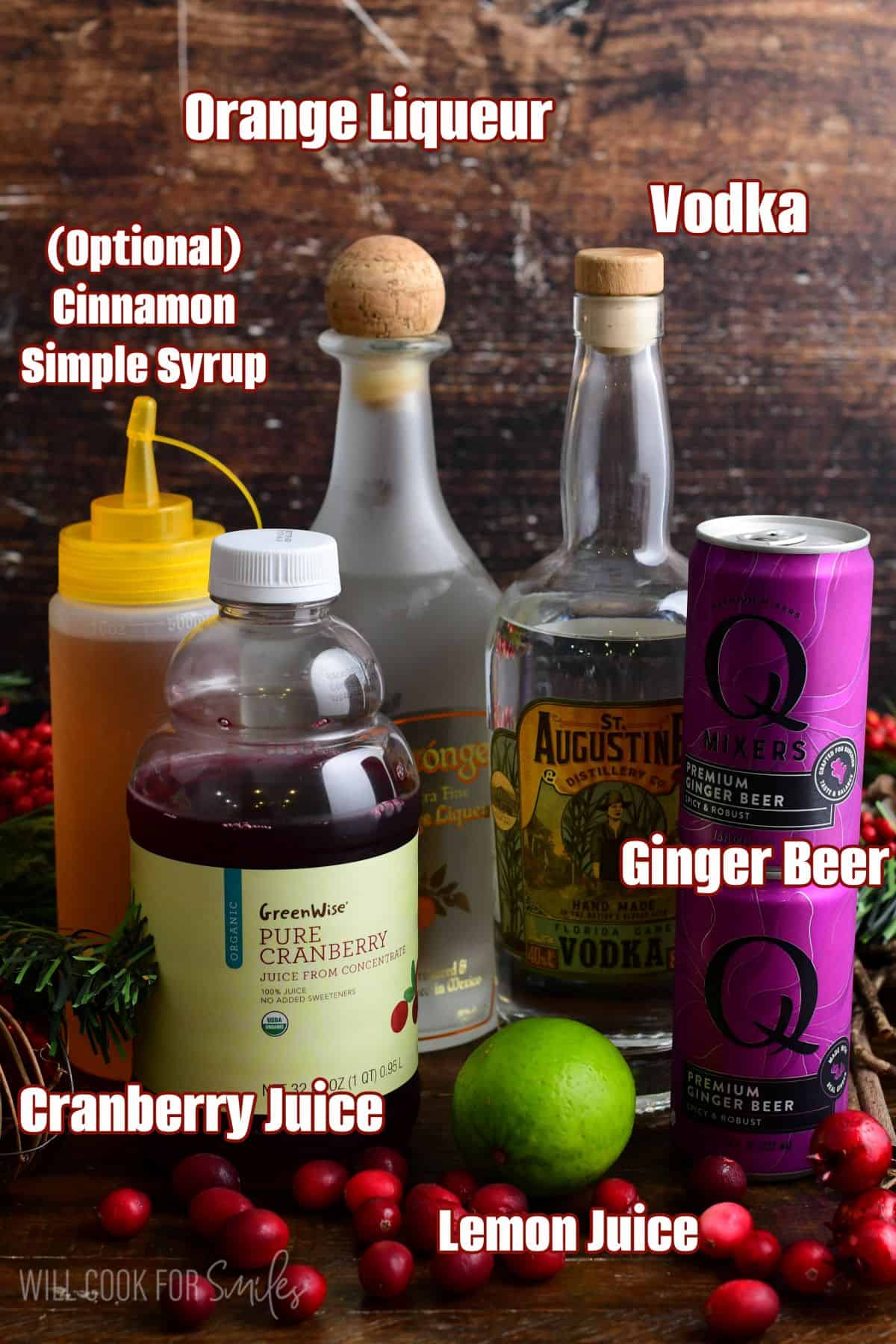 Labeled ingredients for Cranberry Moscow Mule on a wood surface.