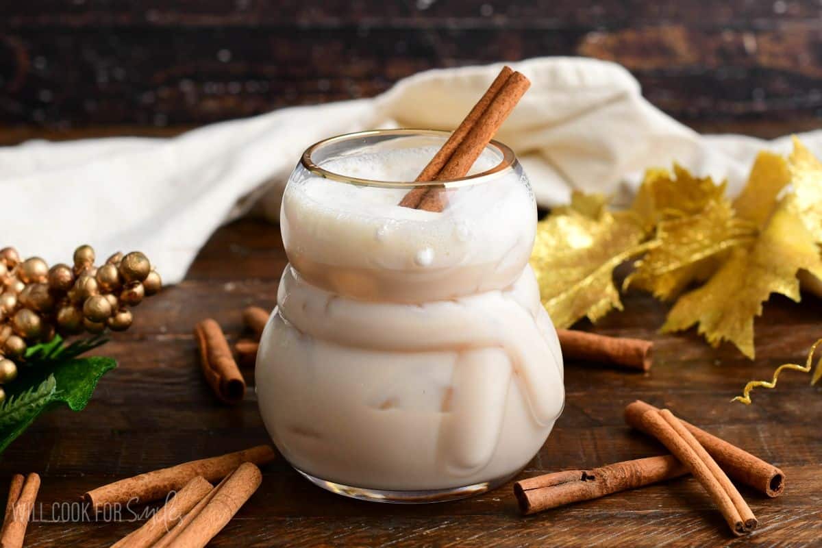 Rumchata cocktail in a snowman glass with a cinnamon stick.