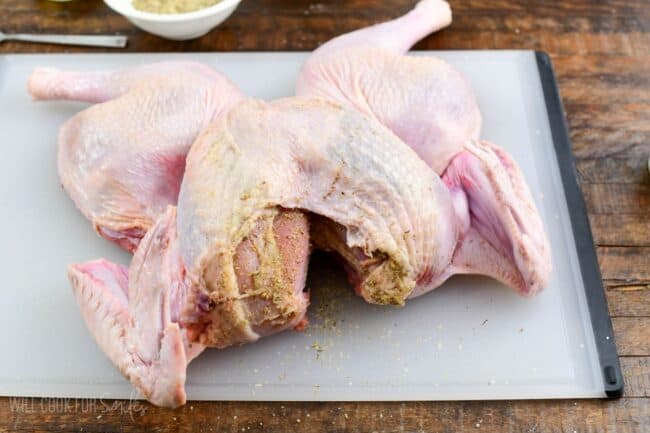 seasoned butterflied turkey on the cutting board.