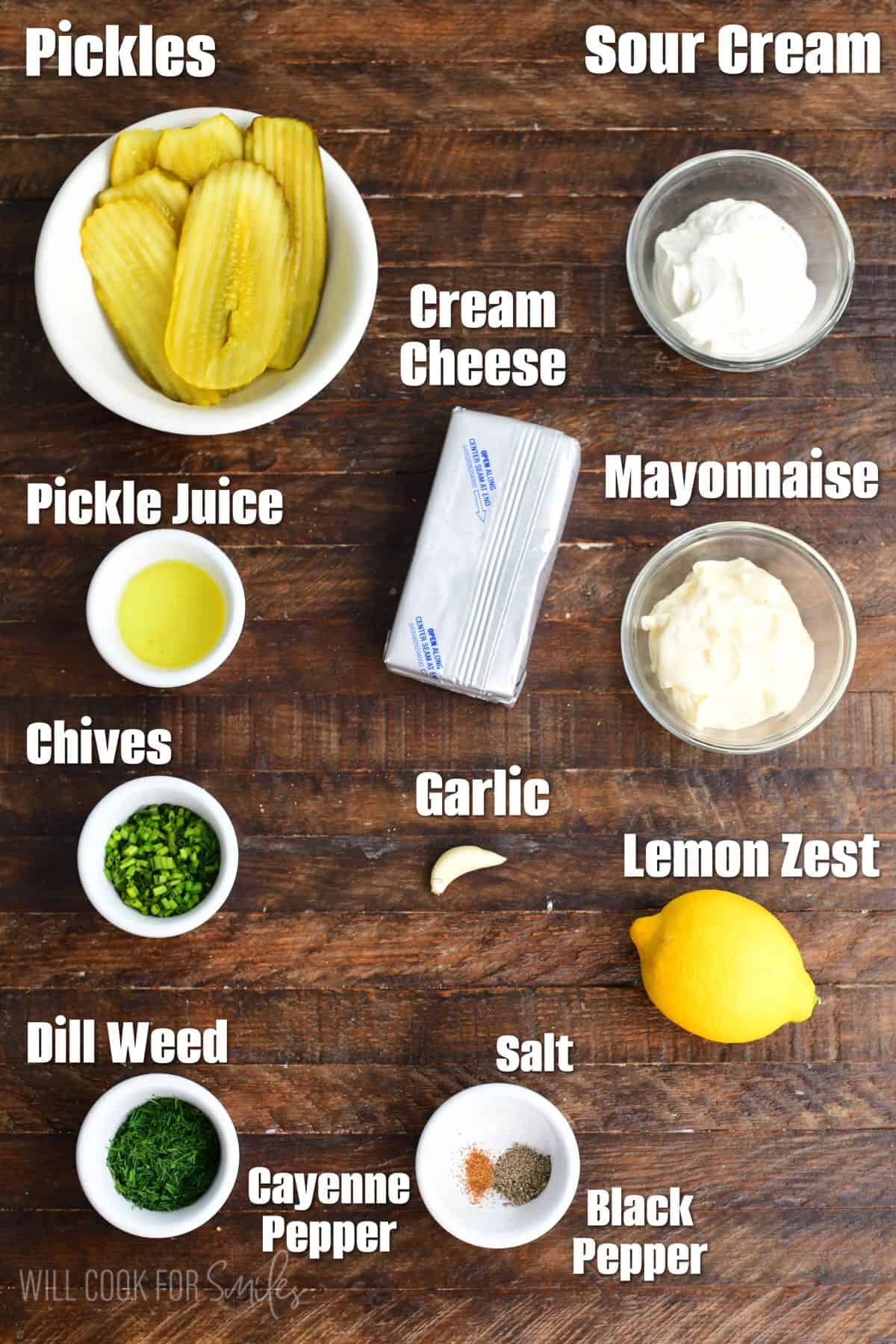 Labeled pickle dip ingredients on a wood surface.