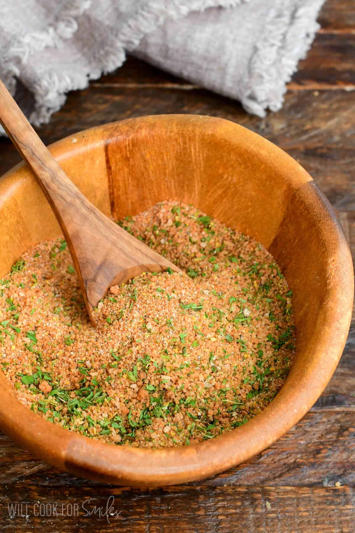 pork rub seasoning in a wooden bowl with a wooden spoon in it.