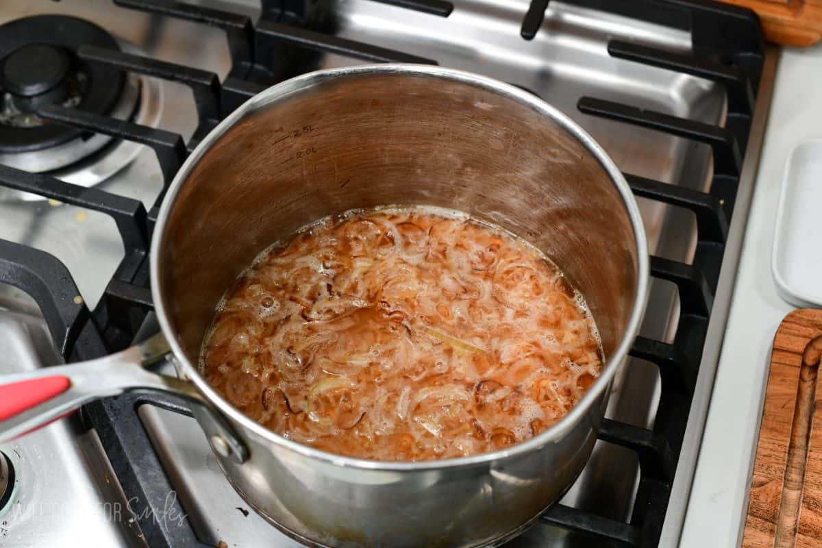 simmering white wine with sauteed shallots in a large silver pot.