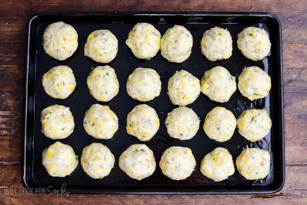 rolled shrimp meatballs on a greased baking sheet before cooking.