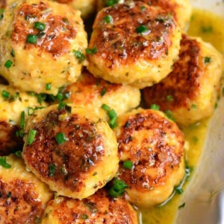 several juicy shrimp meatballs and flavorful scampi sauce in a serving bowl.