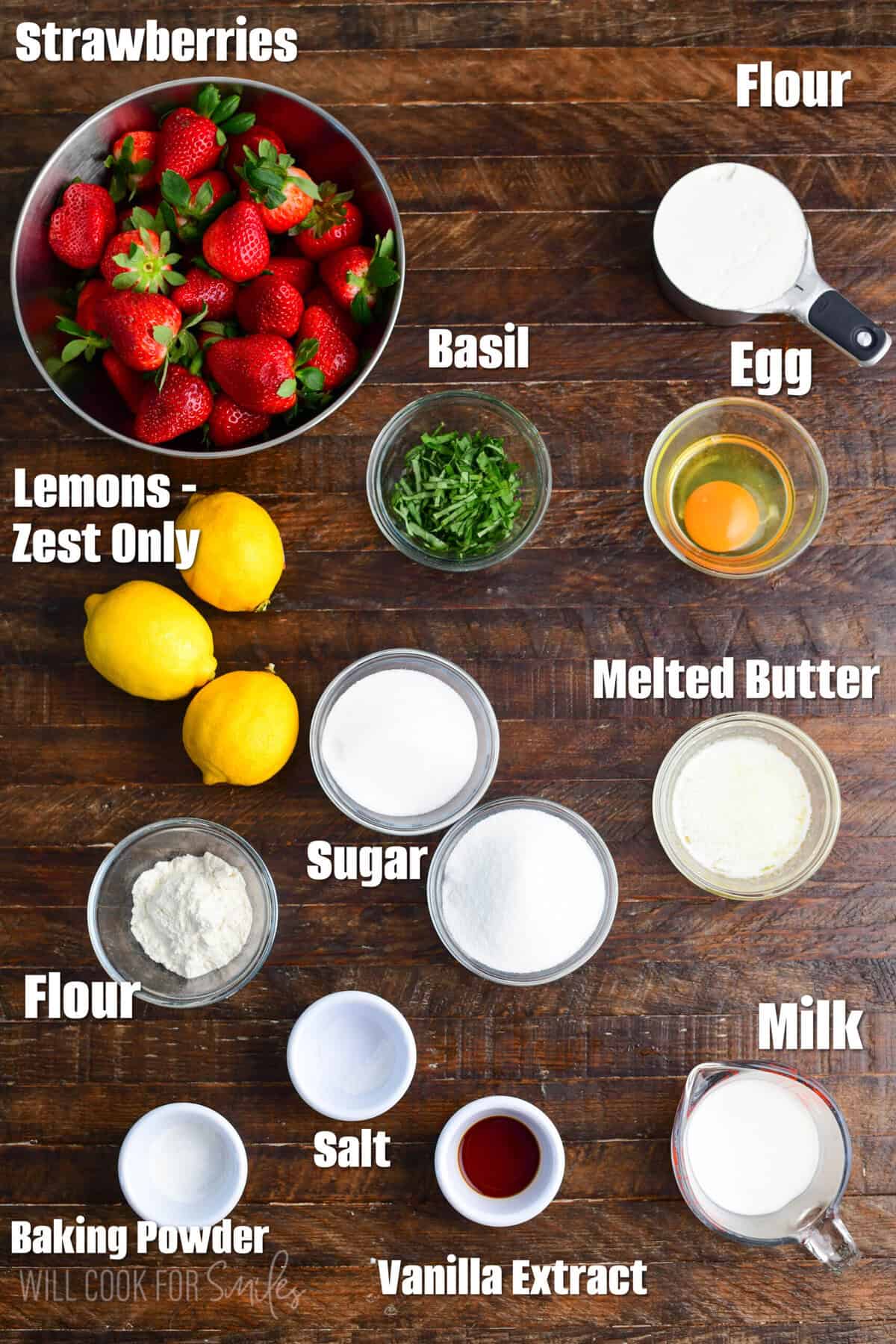 Labeled ingredients for strawberry basil cobbler on a wood surface.