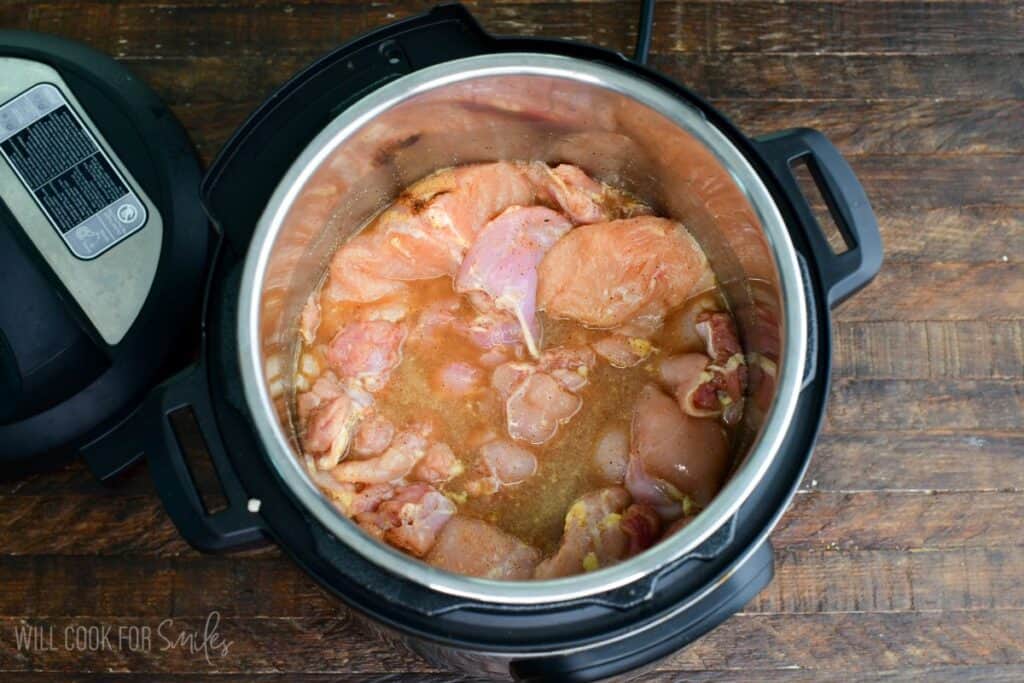 chicken meat covered in seasoned broth in the Instant pot.
