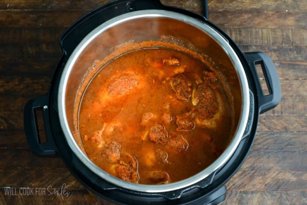 tender cooked chicken breast and thigh meat in salsa broth in the Instant pot.