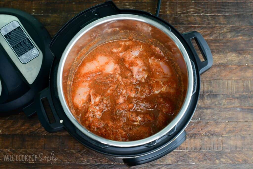 uncooked chicken meat in salsa sauce in the Instant pot.
