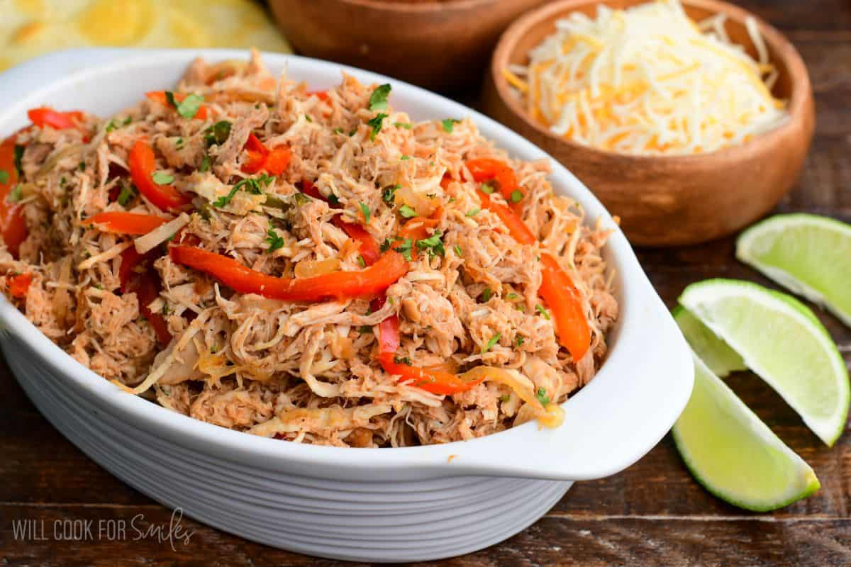 flavorful and tender shredded salsa chicken meat mixed with sauteed vegetables in the serving dish.