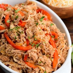 shredded moist and tender salsa chicken mixed with caramelized vegetables in the serving dish.